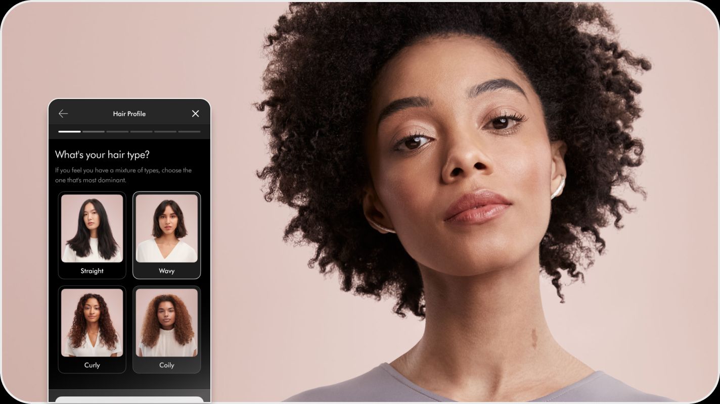 Model with her hair styled stood next to a screen on the MyDyson app which suggests her hair profile options. Model with her hair styled stood next to a screen on the MyDyson app which suggests her hair profile options.